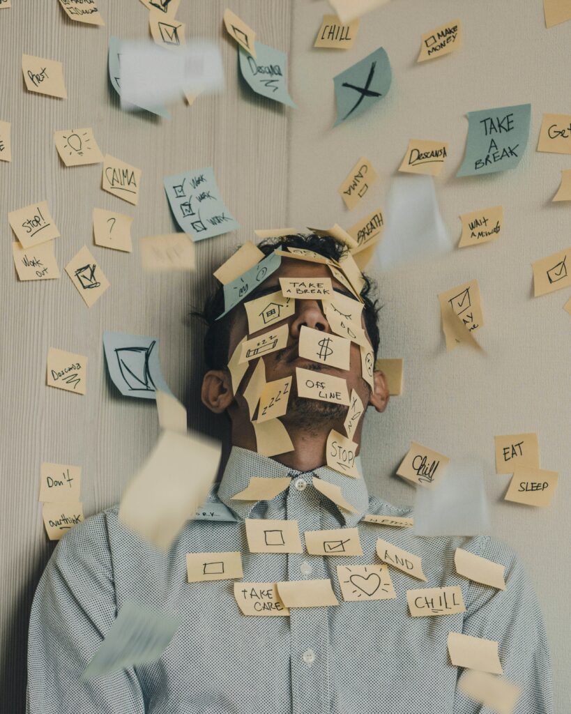 Man standing in a corner with post-its all around and all over him